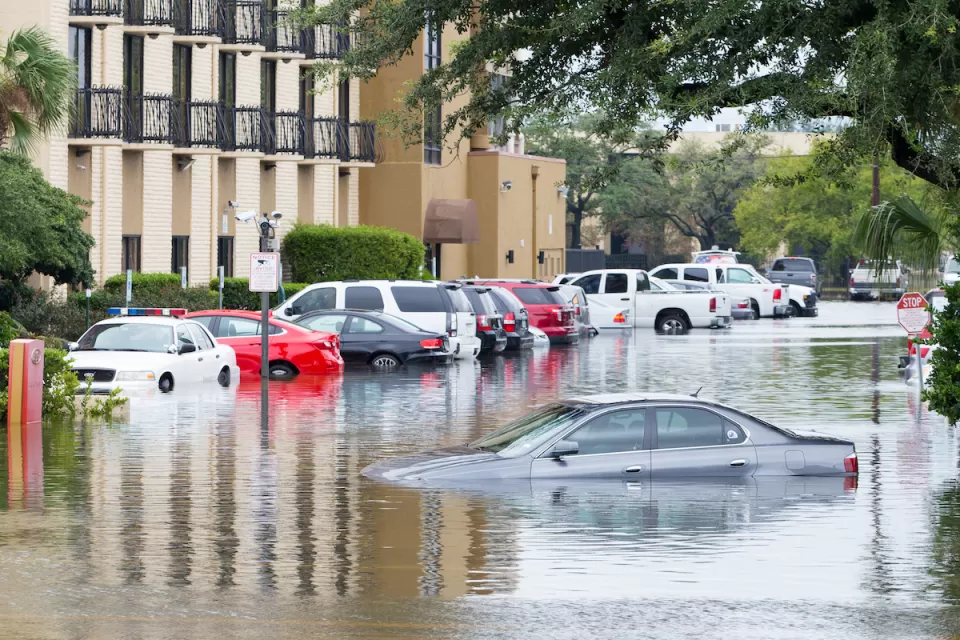 Flooded Houston street with half-submerged cars during Hurricane Harvey.